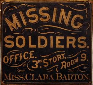 The original metal sign advertising the Missing Soldiers Office. A blue square sign with gold lettering, the sign reads: Missing Soldiers, Office 3rd Story Room 9, Miss Clara Barton