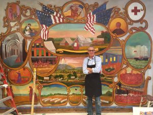 Artist Peter Waddell standing in front of the partially completed mural.